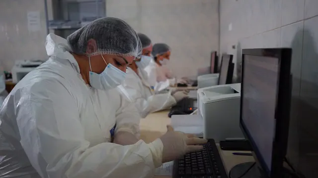 Horizontal video: Healthcare workers in safety gear using computers 28950234. Duration: 12 seconds. Resolution: 1920x1080