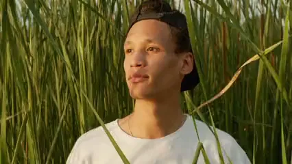 Horizontal video: A young man photo shoot with tall wild grasses as background 4835064. Duration: 11 seconds. Resolution: 3840x2160