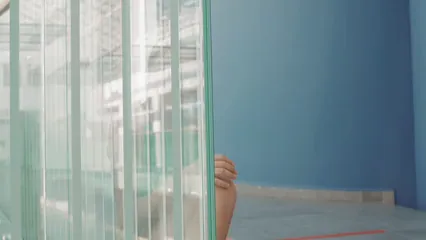 Horizontal video: Close up of a girl hiding beside glass panels 8439478. Duration: 15 seconds. Resolution: 3840x2160