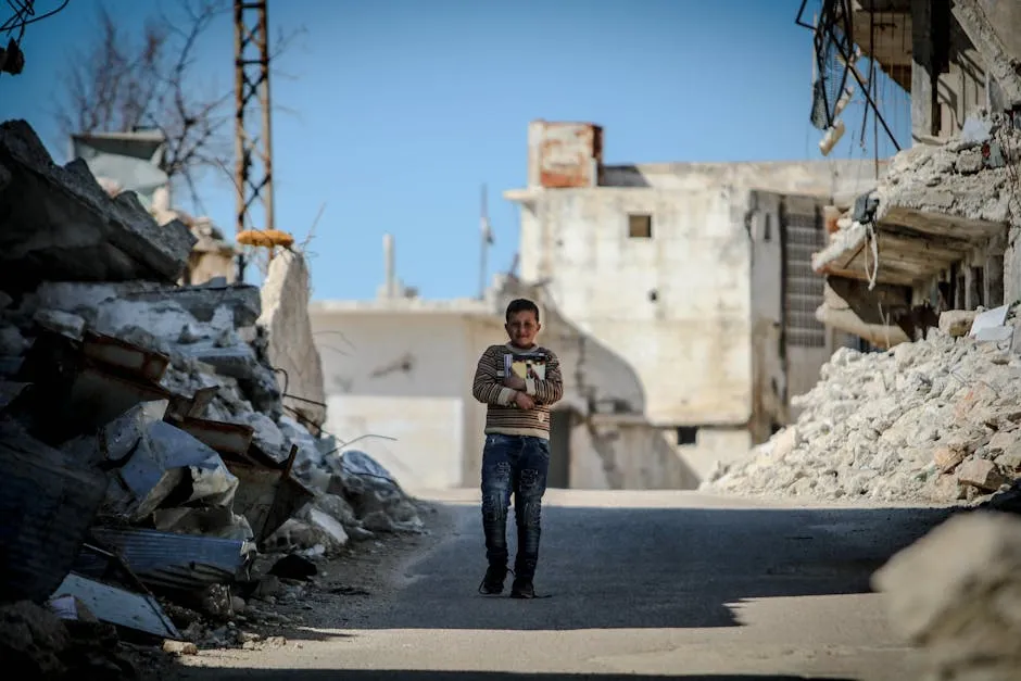 A Young Boy Walking on the Street Between Demolished Houses