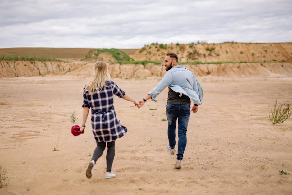 Couple Holding Hands and Walking on Beach