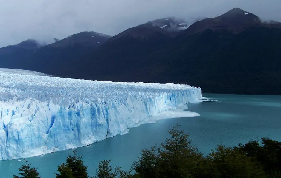Glacier Between Body of Water and Mountains