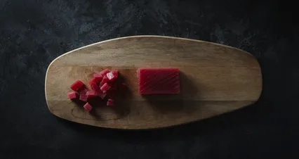 Horizontal video: Placing the sushi knife besides dices and meat of tuna over a wooden chopping board 3296291. Duration: 6 seconds. Resolution: 4096x2160