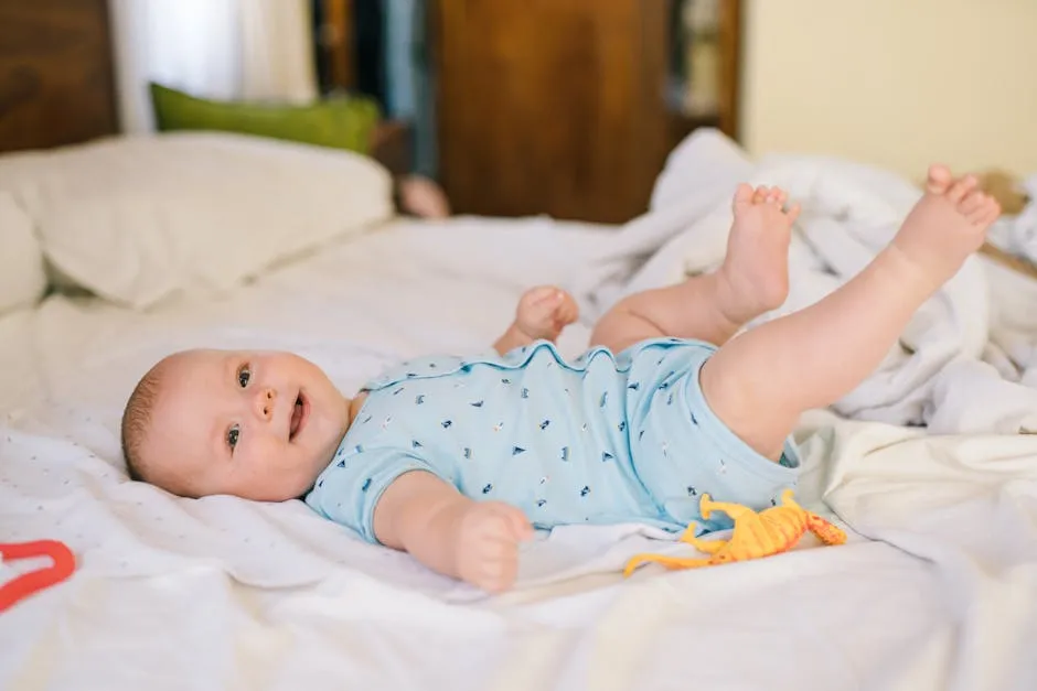 Baby Boy Wearing Blue Onesie while Lying on the Bed