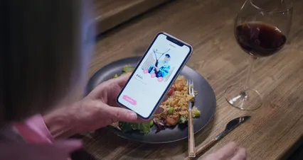 Horizontal video: A woman scrolling through her phone while at the dinner table 6848414. Duration: 50 seconds. Resolution: 4096x2160