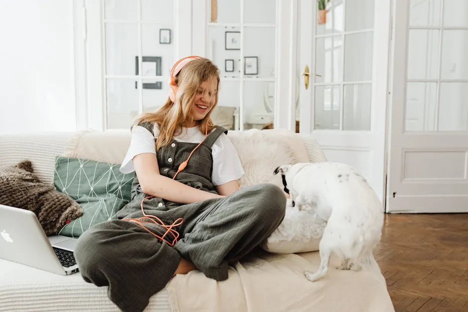 A Teenager Wearing Headphones while Playing with Her Dog