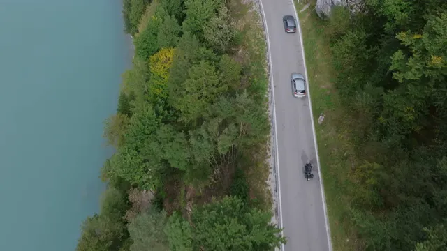 Horizontal video: Scenic aerial view of cars driving by a lake 28963713. Duration: 13 seconds. Resolution: 3840x2160