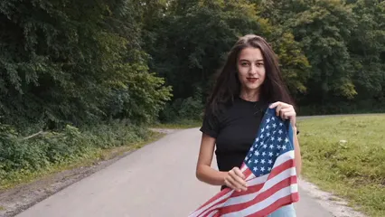 Horizontal video: Young woman holding the american flag 5391316. Duration: 15 seconds. Resolution: 3840x2160
