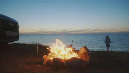 Horizontal video: Woman at the campfire by the sea 5419256. Duration: 65 seconds. Resolution: 3840x2160