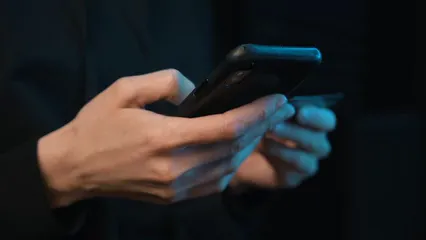 Horizontal video: A person using a cellphone while holding a card 7534329. Duration: 15 seconds. Resolution: 1920x1080