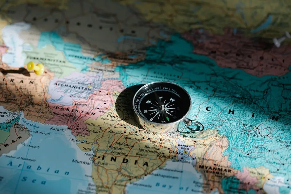 Close-up image of compass on a world map highlighting travel direction and exploration.