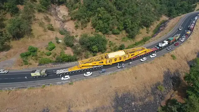 Horizontal video: Aerial shot of heavy equipment driving on the road 8961953. Duration: 27 seconds. Resolution: 1920x1080