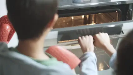 Horizontal video: A person wearing oven mitts while getting out a baked cookies from the oven 6481541. Duration: 9 seconds. Resolution: 3840x2160