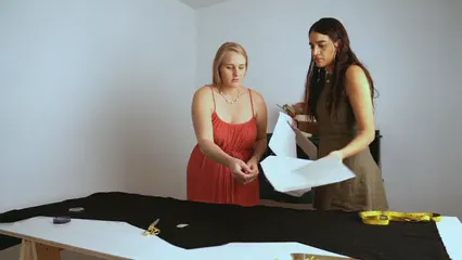 Horizontal video: Women laying out a stencil on top of fabric 7998240. Duration: 9 seconds. Resolution: 1920x1080