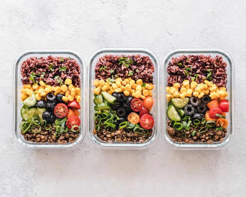 Colorful healthy meal prep with corn, olives, tomatoes, and lentils in glass containers. Perfect for mindful eating.