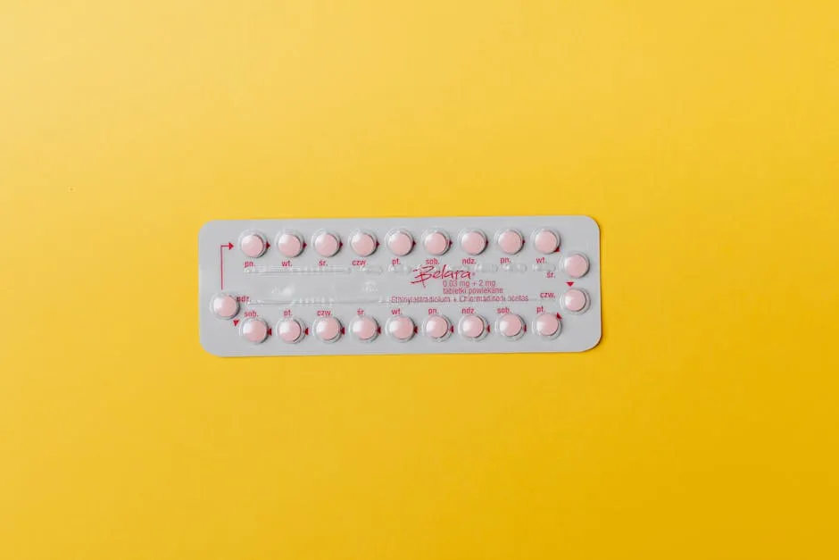 Close-up of a blister pack of pink pills on a vivid yellow background for medication concept.