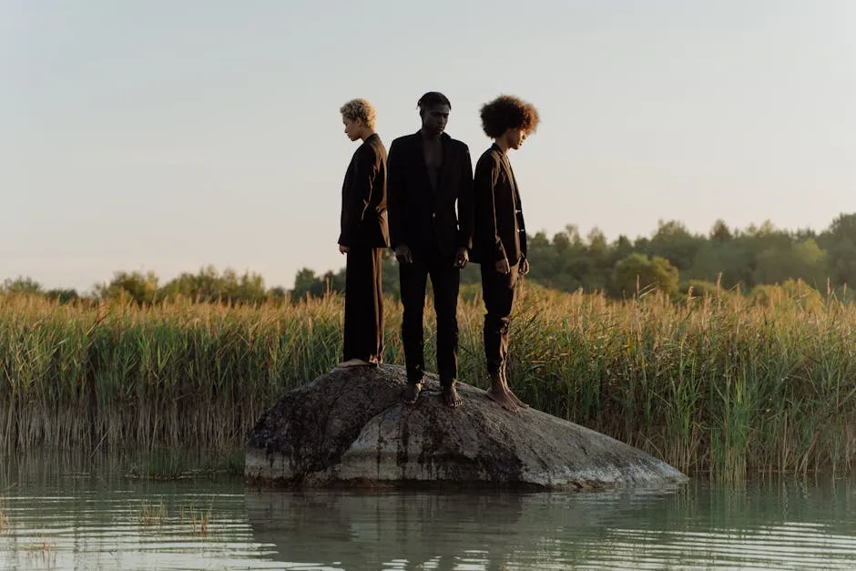 Men and Woman Standing on Rock on Body of Water