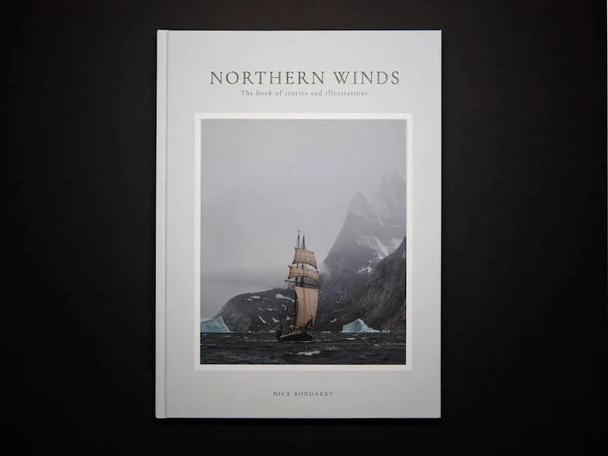 Modern interesting paper book telling about north seas traveling in hardcover with picture of old fashioned ship with white sails near rocky snowy cliff in thick fog on black background