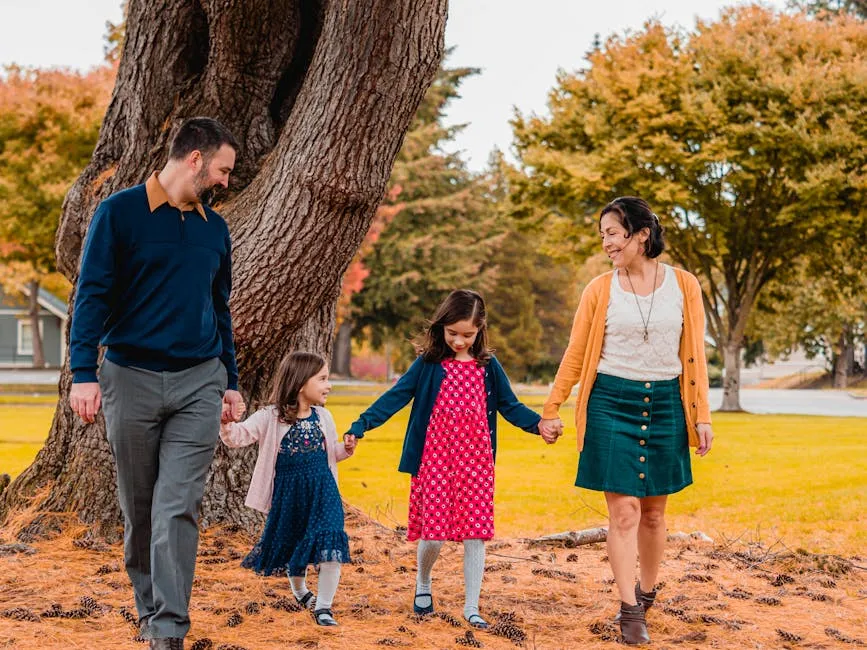 A Happy Family Walking at the Park Together while Holding Hands