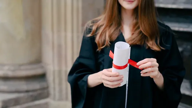 Horizontal video: A woman removing the ribbon and unfolding her college diploma 8284319. Duration: 8 seconds. Resolution: 1920x1080