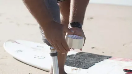 Horizontal video: Surfer putting adhesive tape on prosthetic leg 5905171. Duration: 15 seconds. Resolution: 3840x2160