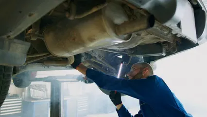 Horizontal video: An auto mechanic inspecting the undercarrige of a vehicle 8987009. Duration: 13 seconds. Resolution: 3840x2160