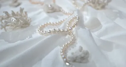 Horizontal video: Close up footage of pearl accessories on a white fabric 9428862. Duration: 24 seconds. Resolution: 4096x2160