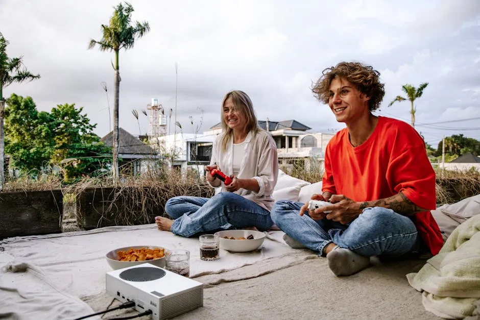 A happy couple playing video games together outside on a sunny day, enjoying leisure time.