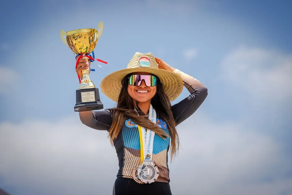 Smiling sportswoman celebrates victory outdoors with golden trophy and medals.