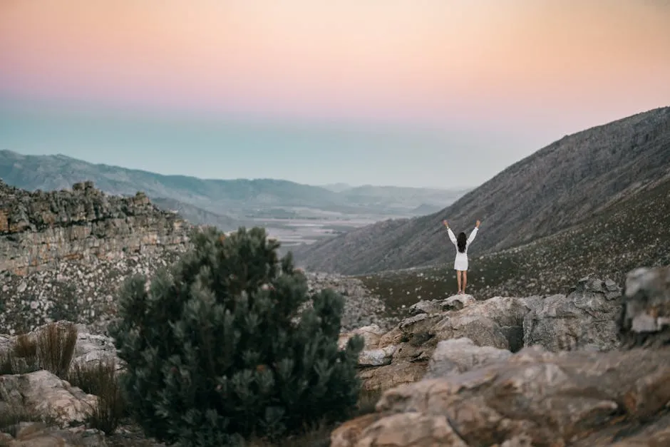 Photo of a Woman Standing In the Middle of a Rocky Mountain