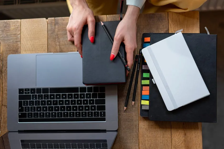 Top-down view of a desk with laptop, planner, and notebooks. Perfect for business and productivity themes.