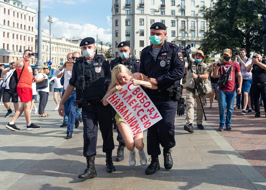 Protester being detained by police during an urban demonstration in broad daylight.