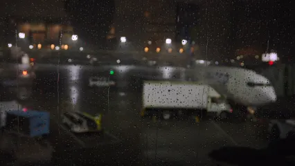 Horizontal video: Amidst a thunderstorm s fury at newark liberty international airport the tarmac is lashed with torrential rain and illuminated by flashes of lightning while airplanes patiently remain at 16954769. Duration: 7 seconds. Resolution: 3840x2160