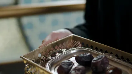 Horizontal video: A woman holding a tray of dates and a glass of water 8166044. Duration: 8 seconds. Resolution: 3840x2160