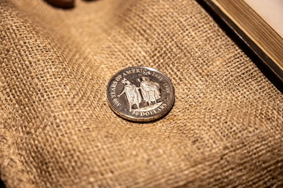 Close-up of an antique American coin on burlap fabric emphasizing historical value.