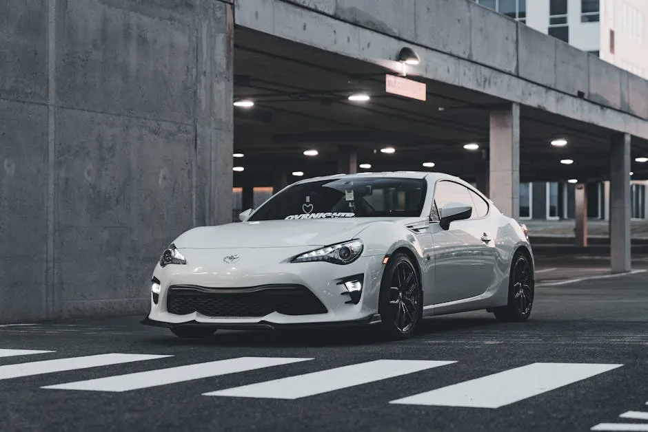 A sleek white sports car parked in an urban setting at twilight, showcasing luxury and style.