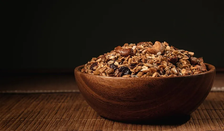 A rustic wooden bowl filled with nutritious granola, nuts, and seeds on a wooden surface.
