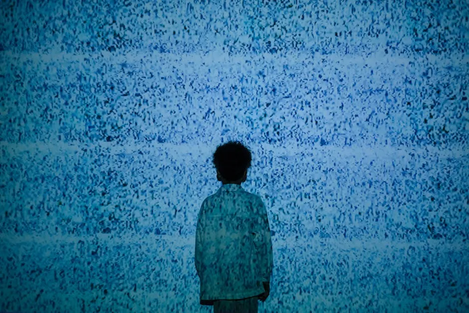 A child stands silhouetted against a wall showing static noise, evoking themes of media influence.