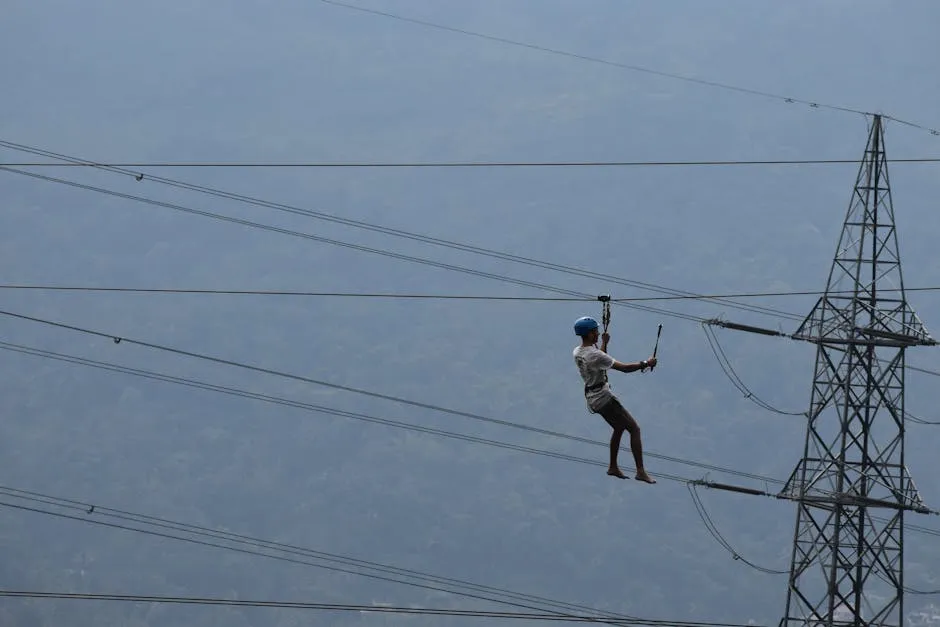 Person Working at Heights next to the Transmission Tower 