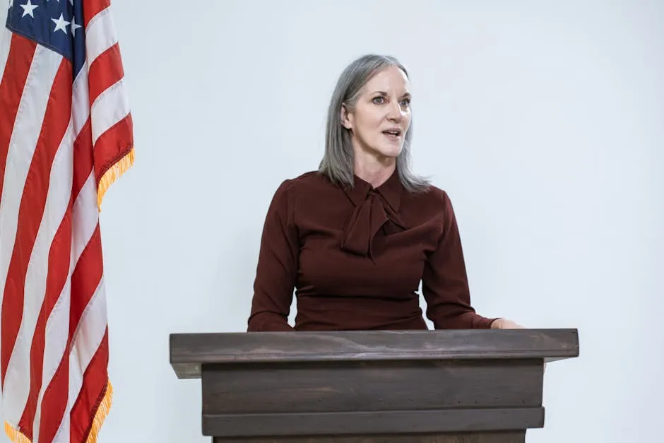 Confident woman delivering speech in front of an American flag, embodying leadership and empowerment.