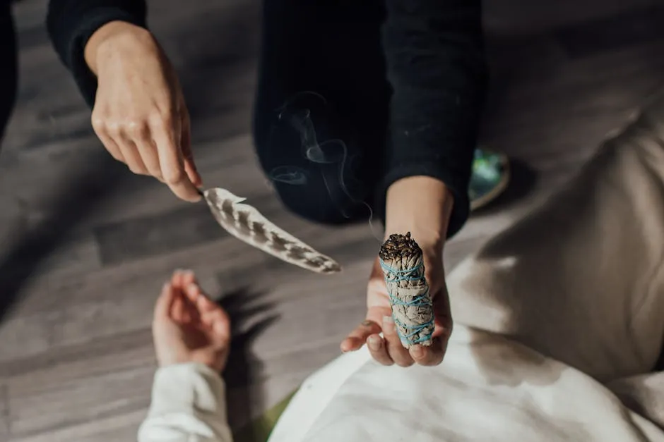 A Person Holding a Smoking Incense and a Feather