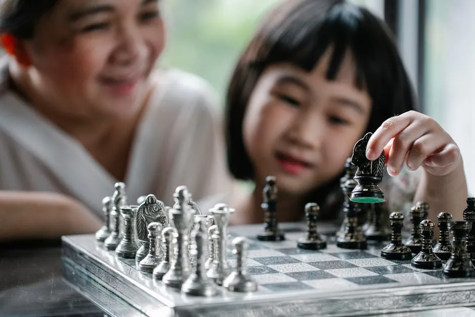 Crop Asian grandmother and girl playing chess together